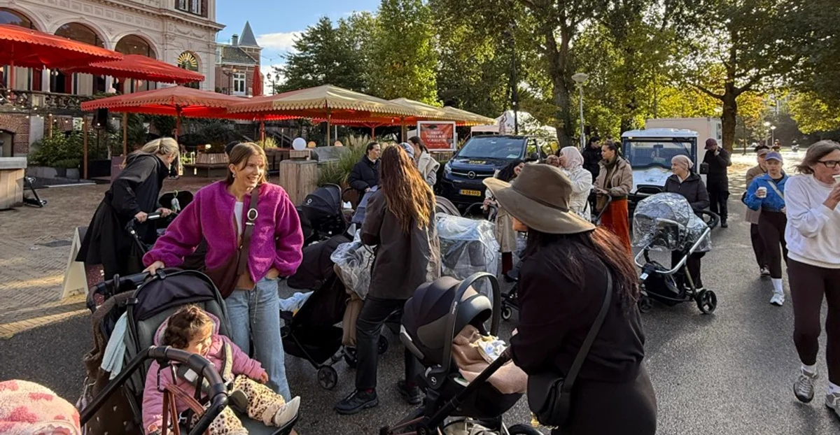 A large group of moms and little ones gathering with strollers outside Cafe Vertigo