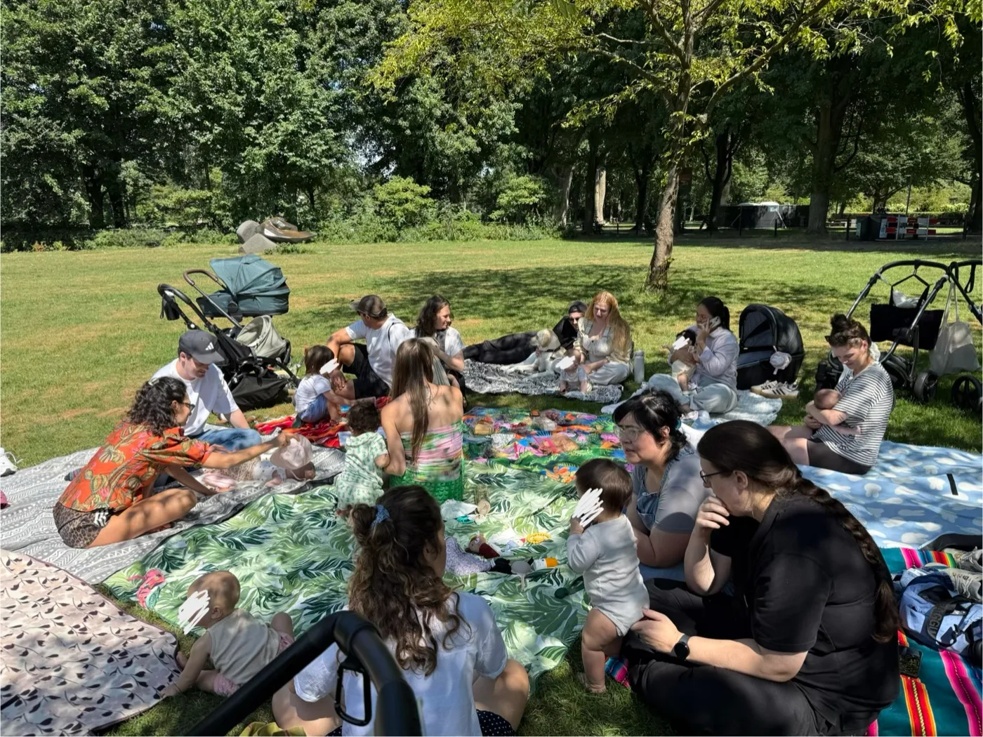 Families gathered on picnic blankets at a sunny Mama Circle picnic